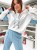 Dres damski, komplet bawełniany w stylu sportowym. Bluza z kapturem w kolorze białym z niebieskimi wstawkami. Spodnie koloru niebieskiego ze zwężanymi nogawkami z przeszyciami z przodu.